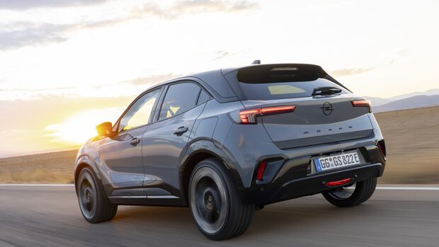 Opel Mokka GSE in Heckansicht während der Fahrt bei Sonnenuntergang.