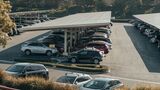 Parkplatz mit mehreren abgestellten Fahrzeugen unter Carports als Symbol für Poolfahrzeuge und Corporate Carsharing.
