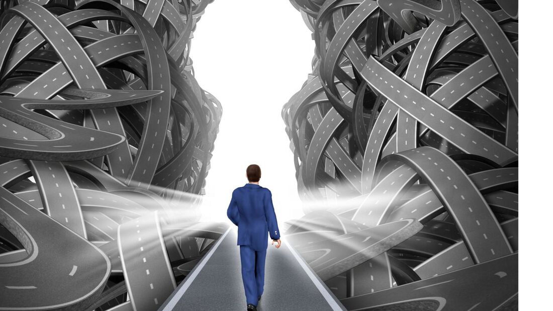 Person in Businesskleidung geht auf einer Straße durch eine komplexe Struktur aus verschlungenen Fahrbahnen, symbolische Darstellung von Mobilitätsentscheidungen.