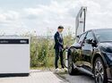Person lädt ein Elektroauto an einer ChargeBox von ADS-TEC Energy im Außenbereich.
