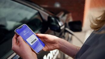 Person nutzt die Monta-Charge-App an einem Ladepunkt für Elektroautos.