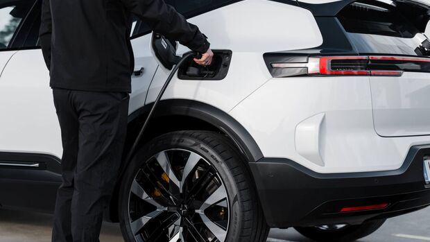 Person verbindet einen Polestar 3 mit einer Ladestation im Außenbereich.