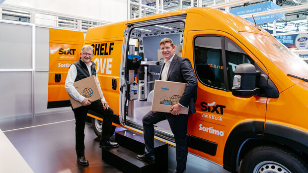 Peter Beermann (SIXT van & truck) und Reinhold Braun (Sortimo) vor dem Sortimo-Regalsystem im Transporter, IAA Transportation 2026.