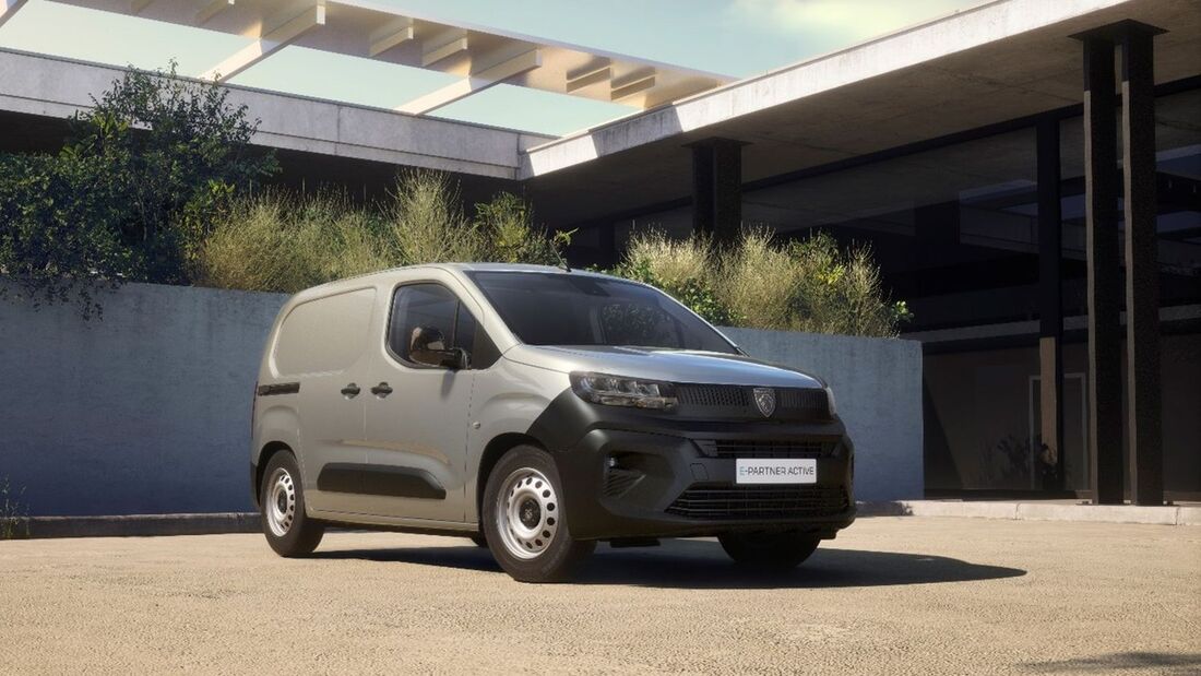 Peugeot E-Partner Active als grauer elektrischer Kastenwagen in Dreiviertelansicht von vorne, geparkt vor einem modernen Gebäude.