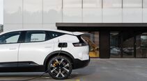 Polestar 3 lädt an einer Außenladestation vor einem Firmengebäude.