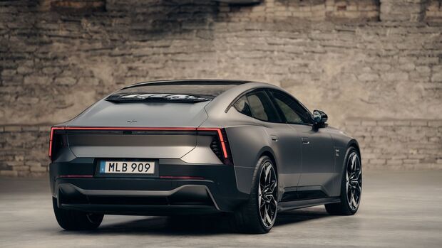 Polestar 5 Exterieur: Heckansicht einer grauen Limousine mit durchgehendem Rückleuchtenband und Kennzeichen MLB 909 in Industrieumgebung.