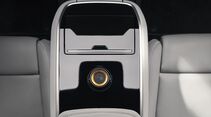 Polestar 5 Interieur: Mittelkonsole im Fond mit glänzender Oberfläche und zentralem Bedienelement zwischen den Rücksitzen.