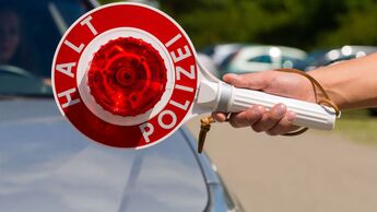 Polizeikontrolle im Straßenverkehr mit Anhaltekelle an einem Pkw zur Überprüfung der Fahreignung des Fahrers.