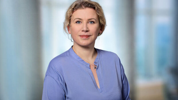 Porträt einer Frau vor unscharfem Innenraumhintergrund im Kontext eines Beitrags zu Freistellung, Kündigung und Dienstwagen.