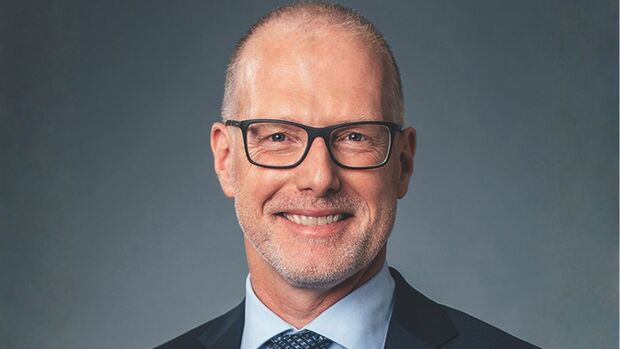 Porträt von Bernd Brauer, Head of Mobility bei Consors Finanz BNP Paribas, vor grauem Hintergrund.