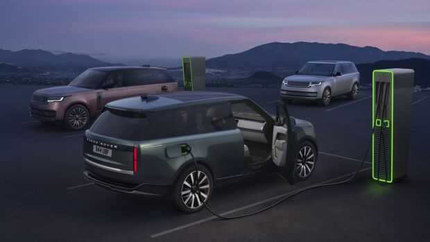 Range Rover Electric beim Laden an einer Schnellladestation, im Hintergrund stehen zwei weitere Fahrzeuge an Ladepunkten.