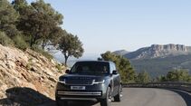 Range Rover Electric fährt auf einer kurvigen Bergstraße vor einer Gebirgslandschaft.