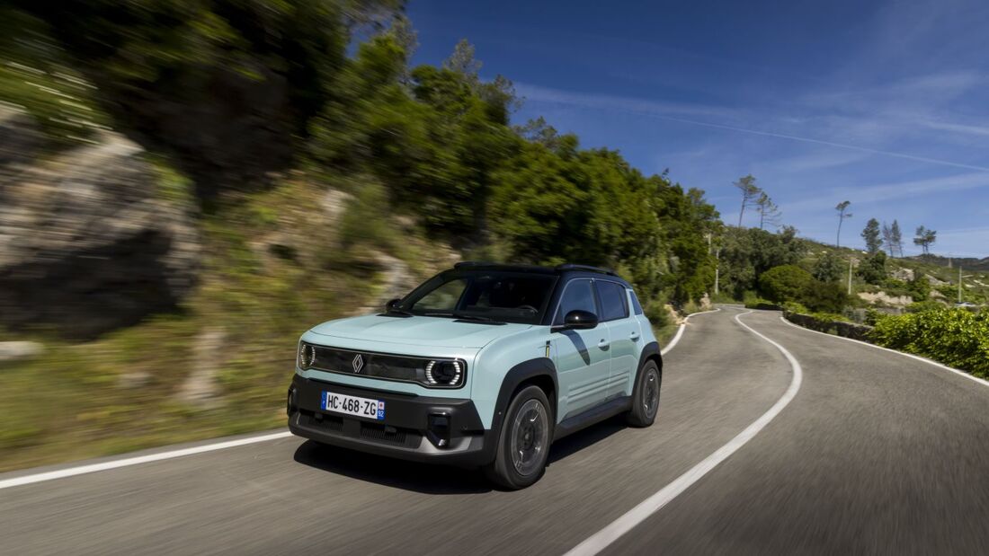 Renault 4 E-Tech in Bewegung auf einer Straße mit Vegetation