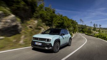 Renault 4 E-Tech in Bewegung auf einer Straße mit Vegetation