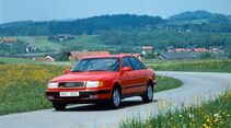 Roter Audi 100 C4 als Limousine mit Allradantrieb quattro auf kurviger Landstraße.