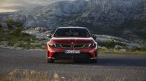 Roter BMW M350 xDrive in direkter Frontansicht auf einer Straße vor einer felsigen Berglandschaft.