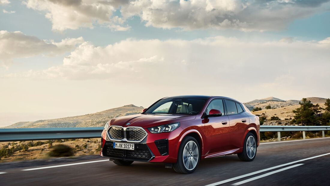 Roter BMW iX2 auf Landstraße, vollelektrisches SUV-Coupé mit neuer Leistungselektronik für das Modelljahr 2026