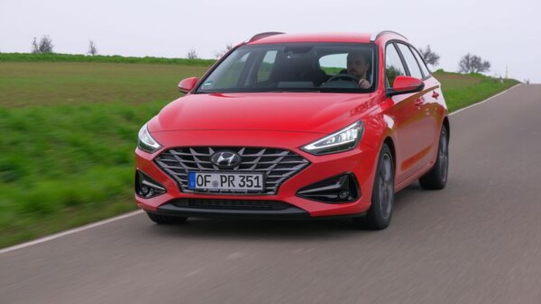 Roter Hyundai i30 in Frontansicht während der Fahrt auf einer Landstraße.