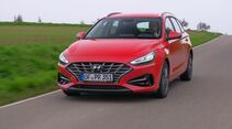 Roter Hyundai i30 in Frontansicht während der Fahrt auf einer Landstraße.