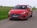 Roter Hyundai i30 in Frontansicht während der Fahrt auf einer Landstraße.