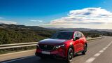 Roter Mazda CX-5 in Frontansicht fahrend auf kurviger Landstrasse mit Berglandschaft