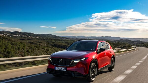 Roter Mazda CX-5 in Frontansicht fahrend auf kurviger Landstrasse mit Berglandschaft