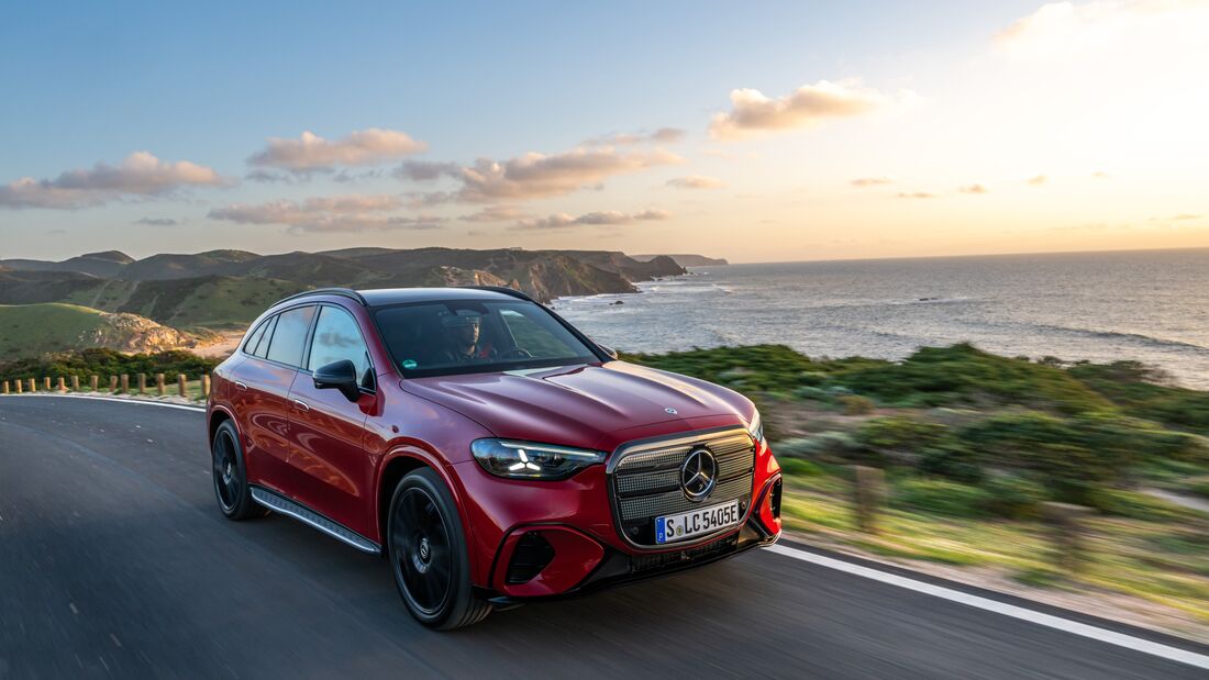 Roter Mercedes GLC mit EQ-Technologie fährt auf Küstenstraße entlang des Meeres