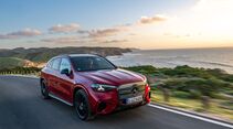 Roter Mercedes GLC mit EQ-Technologie fährt auf Küstenstraße entlang des Meeres
