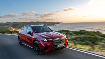 Roter Mercedes GLC mit EQ-Technologie fährt auf Küstenstraße entlang des Meeres