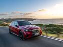 Roter Mercedes GLC mit EQ-Technologie fährt auf Küstenstraße entlang des Meeres