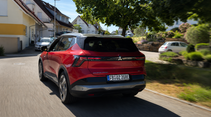 Roter Mitsubishi Eclipse Cross mit E-Kennzeichen fährt durch eine Ortschaft.