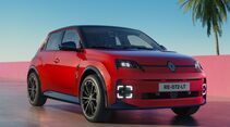 Roter Renault 5 E-Tech Electric in schräger Frontansicht mit schwarzem Dach und eingeschalteter LED-Beleuchtung.