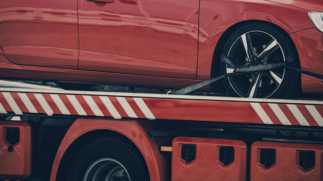 Rotes Auto auf einem Abschleppwagen als Symbol für Abschleppkosten und Standgebühren im Fuhrpark