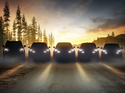 Schattenansicht mehrerer Ford-Modelle mit eingeschalteten Scheinwerfern vor Waldkulisse.