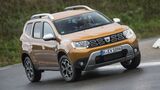 Schräg aufgenommene Frontansicht eines Dacia Duster der zweiten Generation während der Fahrt auf asphaltierter Straße.