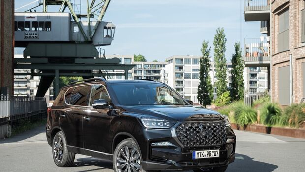 Schwarzer KGM Rexton vor Industriegebäuden – das SUV ist Teil der Rabattaktion für gewerbliche Handwerksbetriebe.
