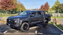 Schwarzer Mitsubishi L200 Doppelkabinen-Pickup in schräger Seitenansicht mit Offroad-Reifen, Radlaufverbreiterungen und Schnorchel.