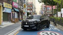Schwarzer Renault Filante SUV steht auf Straße in urbanem Umfeld mit Geschäften