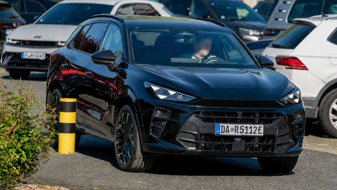 Schwarzes Firmenfahrzeug zwischen mehreren Autos auf einem engen Parkplatz – typische Situation für Rangier- und Parkschäden.