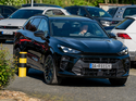 Schwarzes Firmenfahrzeug zwischen mehreren Autos auf einem engen Parkplatz – typische Situation für Rangier- und Parkschäden.