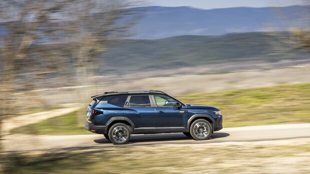Seitenansicht des Dacia Bigster während der Fahrt in ländlicher Umgebung
