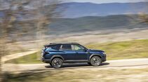 Seitenansicht des Dacia Bigster während der Fahrt in ländlicher Umgebung