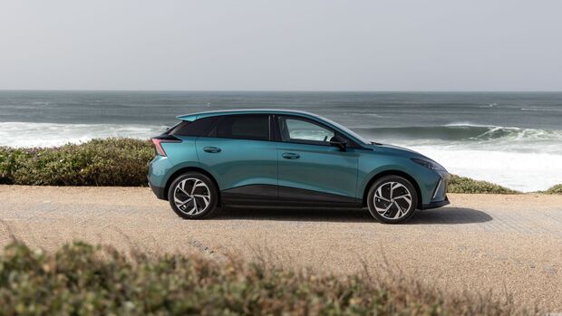 Seitenansicht des MG4 EV Modellpflege im Stand vor einer Meereskulisse.