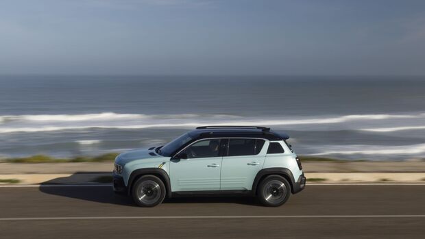 Seitenansicht des Renault 4 E-Tech auf einer Straße entlang der Küste