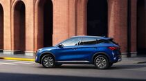 Seitenansicht des blauen BYD Atto 3 Evo Excellence während der Fahrt in einer Stadt.