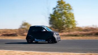 Seitliche Ansicht eines getarnten smart #2 Prototyps bei Testfahrten auf abgesperrter Strecke.