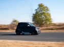 Seitliche Ansicht eines getarnten smart #2 Prototyps bei Testfahrten auf abgesperrter Strecke.