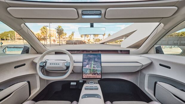 Seitliche Innenraumansicht des Škoda Vision O mit vorderen Einzelsitzen und Rückbank, Türen geöffnet, helles Interieur.