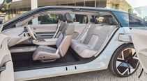 Seitliche Innenraumansicht des Škoda Vision O mit vorderen Einzelsitzen und Rückbank, Türen geöffnet, helles Interieur.
