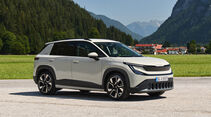 Skoda Epiq in Perlweiß von vorne auf einer Wiese vor einem Tiroler Dorf mit typischen Berghäusern.